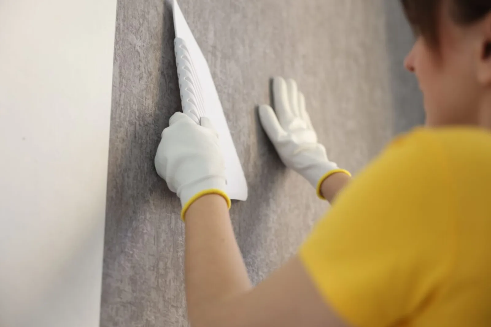 Woman Smoothing Stylish Gray Wallpaper Room Closeup